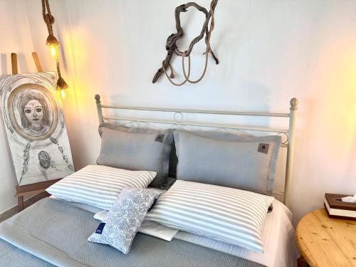 a bed with two pillows on it in a room at ARTE MARE d'Irene in Spárton