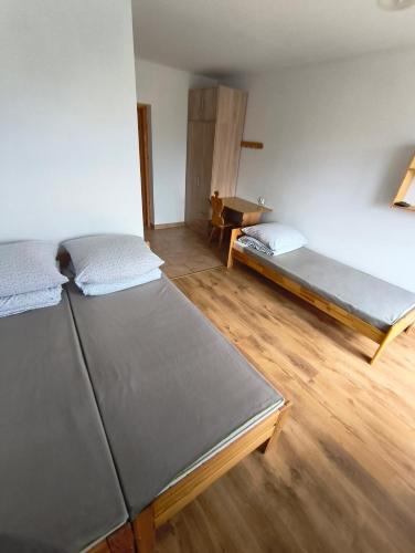a room with two beds and a wooden floor at Wynajem Pokoi Maria Sowińska in Biały Dunajec