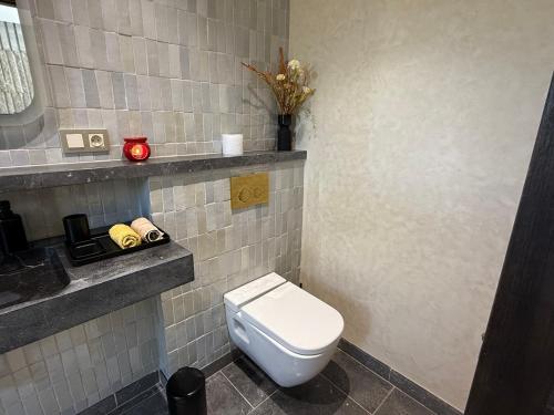 a bathroom with a white toilet and a sink at Maison de campagne in Fès