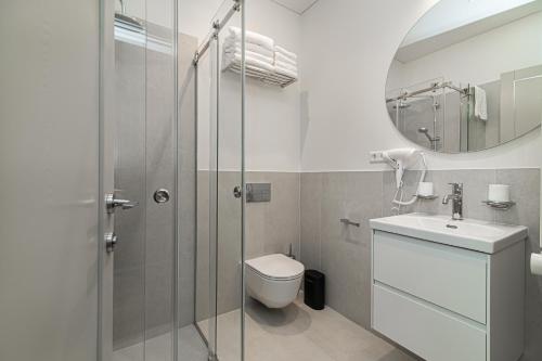 a bathroom with a shower and a toilet and a sink at Royal Horse Resort in Balkasodis