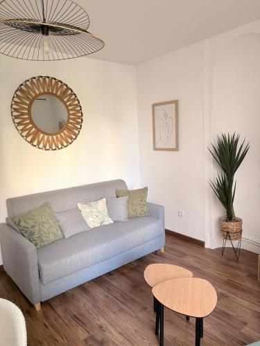 a living room with a couch and a mirror at Le Clos Mignon in Besançon