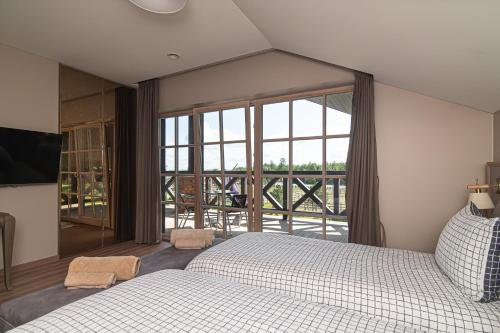 a bedroom with a bed and a large window at Royal Horse Resort in Balkasodis