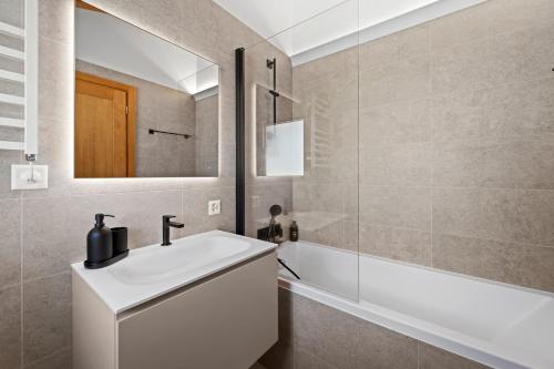 a bathroom with a sink and a mirror and a tub at Abitaziun Stauffacherin 3 - Pontresina in Pontresina