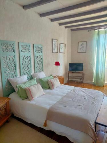a bedroom with a large white bed with pillows at Les Grands Vents in Chervettes