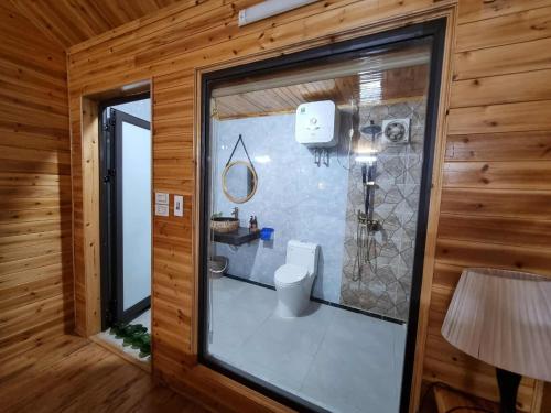 a bathroom with a toilet and a shower in a room at Quyen Homestay in Bắc Hà