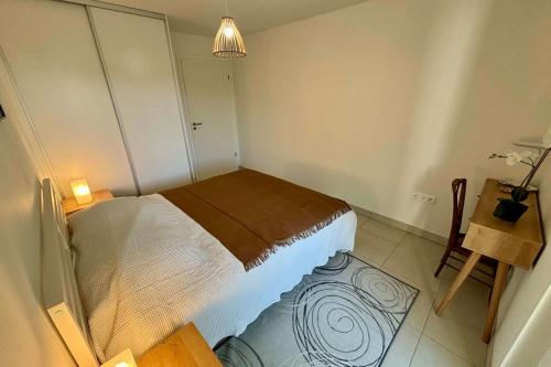 a small bedroom with a bed and a table at New apartment with large terrace! in Illkirch-Graffenstaden