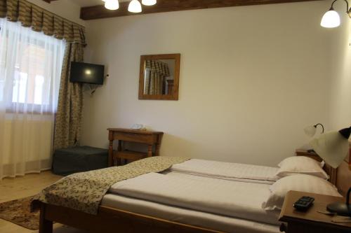 a bedroom with a bed and a table and a television at Arnica Montana in Arieşeni