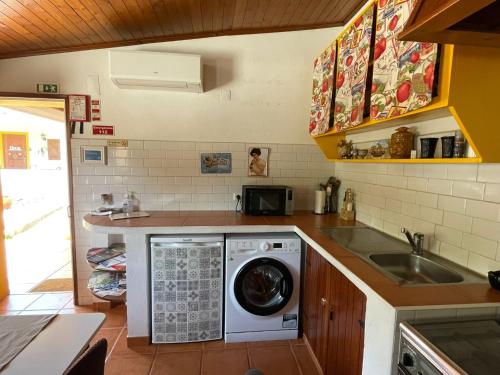 a kitchen with a washing machine and a sink at DEl Rey Guest House in Tomar