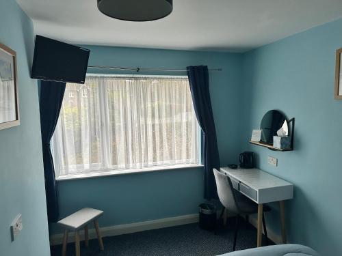 una stanza blu con una scrivania e una finestra di Rothay House ad Ambleside