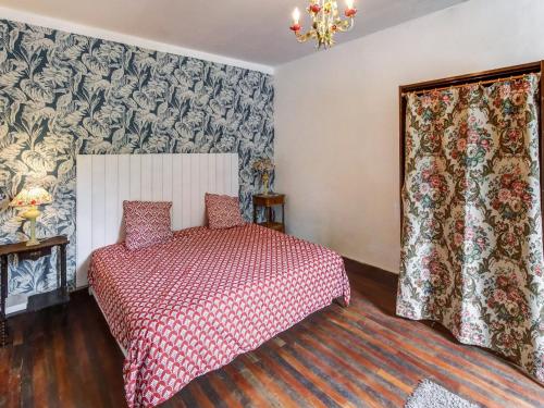 una camera da letto con un letto con un copriletto rosso di Traditional Holiday Home in Brinon sur Beuvron a Brinon-sur-Beuvron