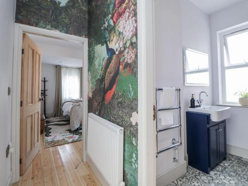 a bathroom with a painting of birds on the wall at 33 Lorne Street in Chester