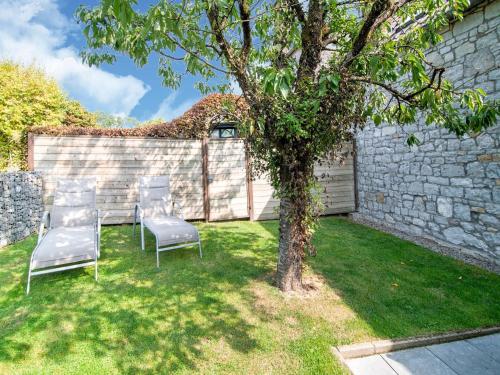 a group of chairs and a tree in a yard at Traditional Cottage with private terrace in Amas