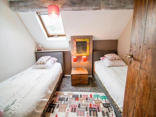 a attic bedroom with two beds and a window at Traditional Cottage with private terrace in Amas