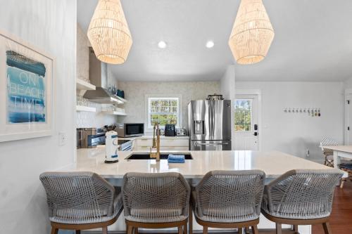 a kitchen with a large island with bar chairs at Stay Salty by Coastline Vacation Rentals in Cape San Blas