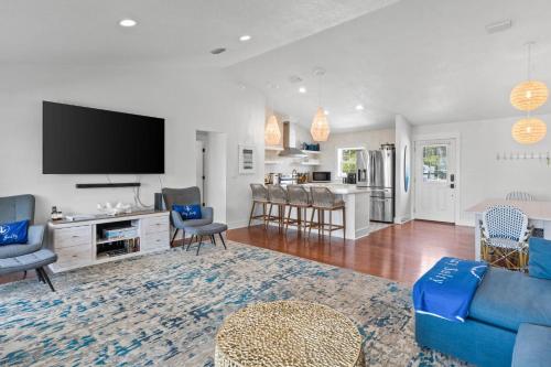 a living room with a blue couch and a kitchen at Stay Salty by Coastline Vacation Rentals in Cape San Blas