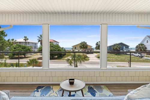 a living room with a large window with a view of the ocean at Stay Salty by Coastline Vacation Rentals in Cape San Blas