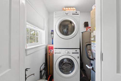 a laundry room with a washing machine and a washer at Stay Salty by Coastline Vacation Rentals in Cape San Blas
