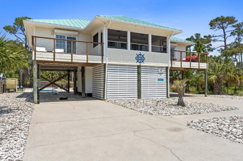 a house on the beach with a balcony at Stay Salty by Coastline Vacation Rentals in Cape San Blas
