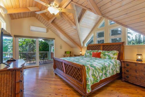a large bedroom with a bed and large windows at Paradiso Hale in Princeville