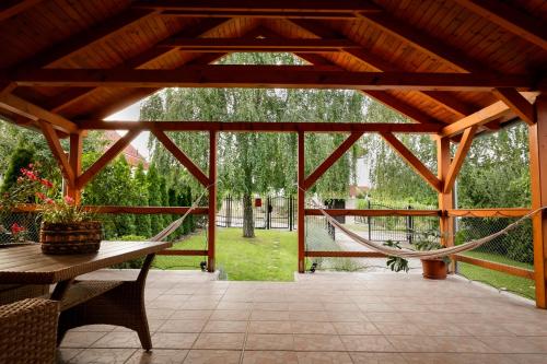 a screened porch with a hammock and a swing at Panoráma Faház Mohács in Mohács