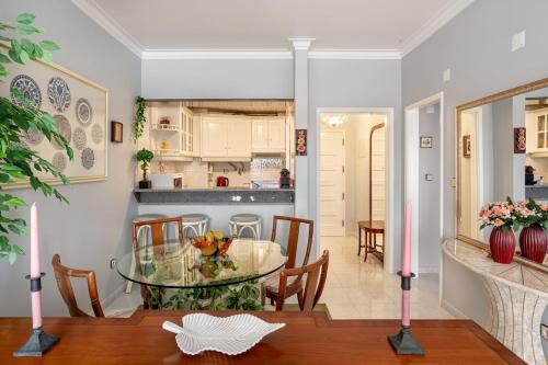 una sala da pranzo e una cucina con tavolo e sedie in vetro di GuestReady - Vibrant flat w/ balcony a Costa da Caparica