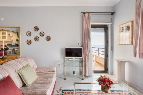 un soggiorno con un divano e una televisione di GuestReady - Vibrant flat w/ balcony a Costa da Caparica