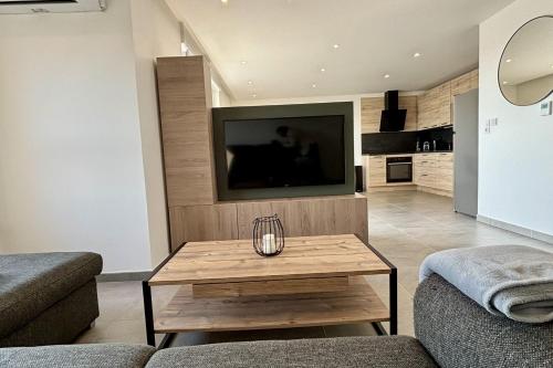 a living room with a tv and a coffee table at Air-conditioned Apartment with terrace in Illkirch-Graffenstaden