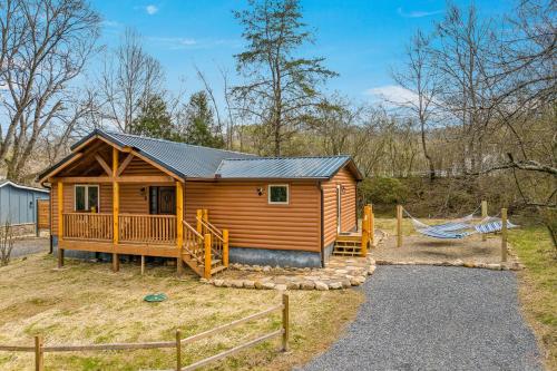 a log cabin with a porch and a fence at Made In The Shade by American Patriot Getaways in Shady Grove