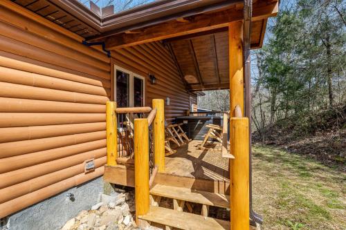 a porch of a log cabin with wooden stairs at Made In The Shade by American Patriot Getaways in Shady Grove