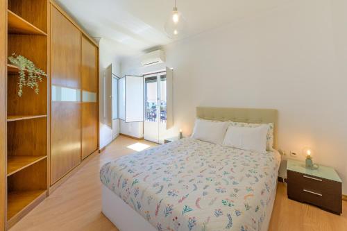 a bedroom with a large bed and a book shelf at Casa Vila-mar Porto Covo in Porto Covo