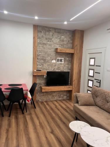 a living room with a couch and a television at Apartaments Rene & Devin in Pogradec