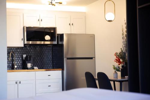 a kitchen with a stainless steel refrigerator and a table at The Irish Inn Boutique Hotel in Shamrock
