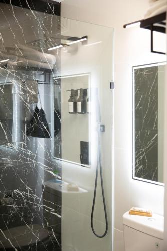 a bathroom with a shower with a glass door at The Irish Inn Boutique Hotel in Shamrock