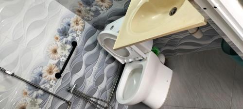 a white toilet in a room with a wall at sri sayang apartment in Batu Ferringhi