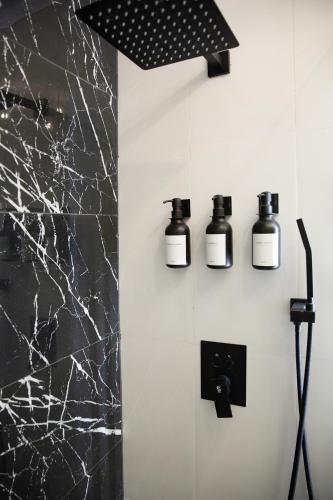 a bathroom with three bottles on the wall at The Irish Inn Boutique Hotel in Shamrock