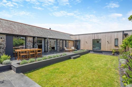 an internal courtyard of a house with a lawn at Woodside Barn Hartland in Hartland