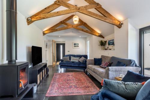 a living room with a couch and a fireplace at Woodside Barn Hartland in Hartland