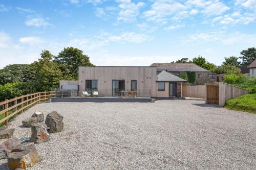 a barn style house with a gravel driveway at Woodside Barn Hartland in Hartland