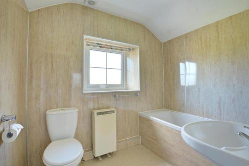 Un baño con inodoro, bañera y lavabo. en The School House, en Walton West