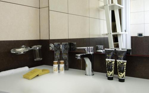 a bathroom with a counter with a sink and a sink at Wellness Spa Hotel Principe Fitalia in Siracusa
