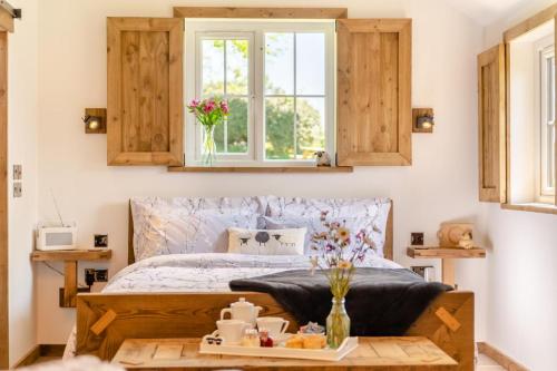 a bedroom with a bed and a table with food on it at Place Farm Cabin in Okehampton