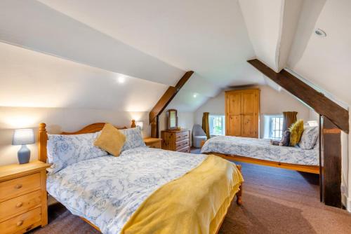 Un dormitorio con dos camas en un ático. en Buckinghams Leary, en West Buckland