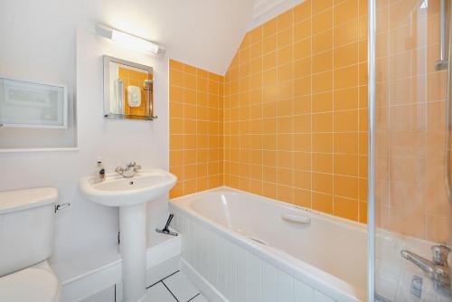 a bathroom with a sink and a tub and a toilet at St Brides Bay Sea View in Broad Haven