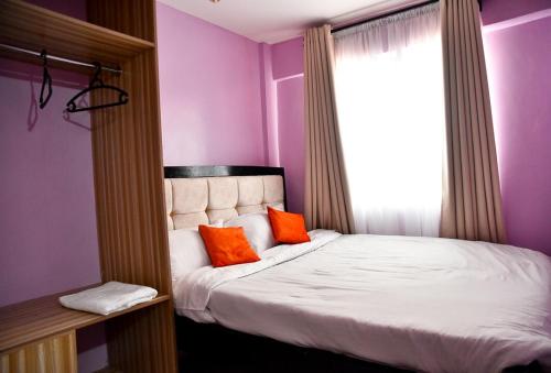 - une chambre avec un lit et deux oreillers orange dans l'établissement Smart 1BR Apartment in Meru Fast Wi-Fi Near Kinoru Stadium, à Gatunga