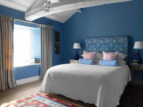 a blue bedroom with a bed and a window at 4 Bed in Askham SZ264 in Askham