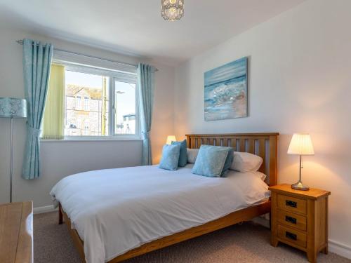 ブリクサムにある2 bed in Brixham 78185の青い枕と窓のあるベッドのある寝室