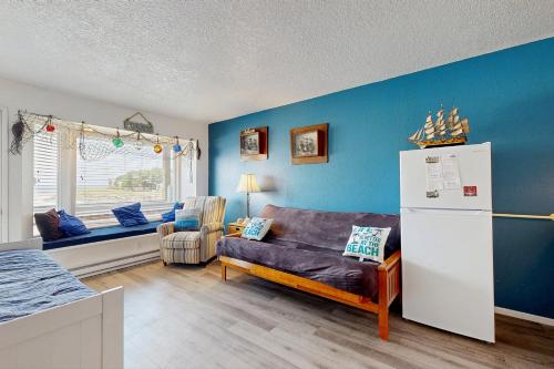 a living room with blue walls and a refrigerator at Neskowin Resort Unit #203 in Neskowin