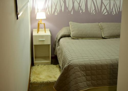 - une chambre avec un lit et une lampe sur une table de chevet dans l'établissement EcoMódulos Termas Villa Elisa, à Villa Elisa