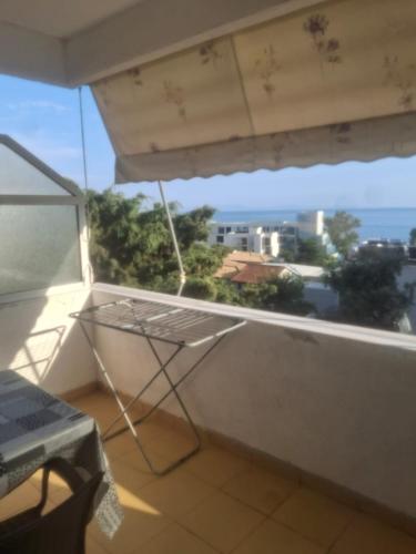 a balcony with a table and a view of the ocean at Hotel Rooms jf DHERMI in Dhërmi