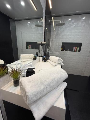 a bathroom with two sinks and white towels at Jas Pipera Studio & Private Pool in Voluntari